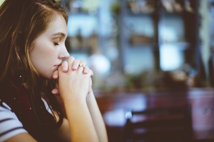 Moça jovem rezando